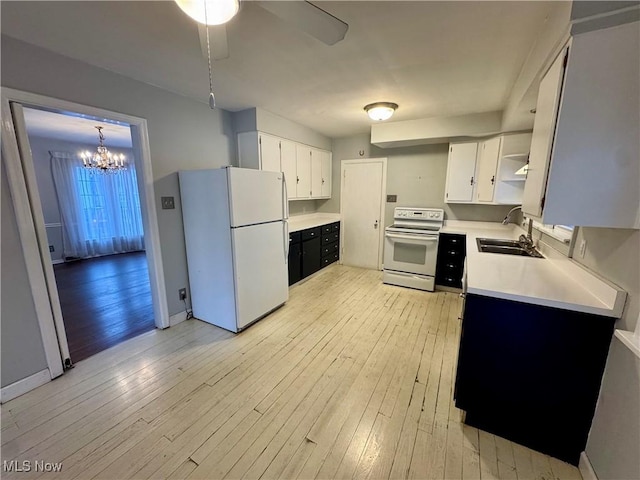 kitchen featuring white appliances, sink, light wood-type flooring, decorative light fixtures, and white cabinetry