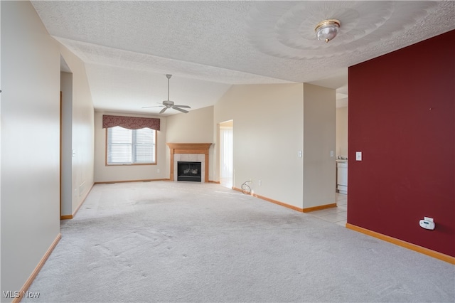 unfurnished living room featuring a textured ceiling, light carpet, ceiling fan, and vaulted ceiling