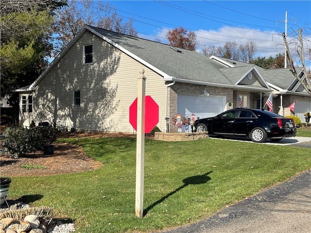 view of side of property with a yard and a garage