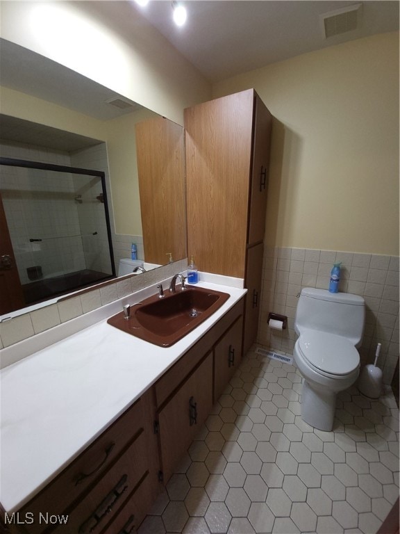 7596 W 130th St, Middleburg Heights, OH 44130 - bathroom featuring vanity, tile patterned floors, toilet, tile walls, and walk in shower