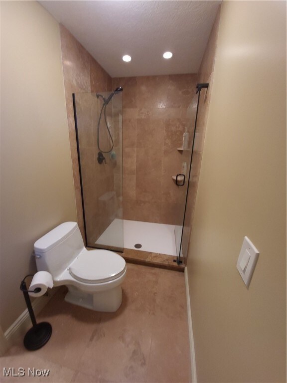 7596 W 130th St, Middleburg Heights, OH 44130 - bathroom with tile patterned flooring, a tile shower, and toilet