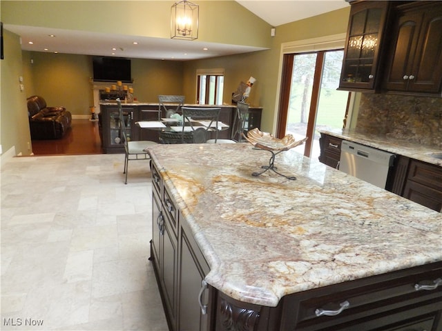7596 W 130th St, Middleburg Heights, OH 44130 - kitchen with dishwasher, lofted ceiling, dark brown cabinets, a kitchen island, and light stone counters