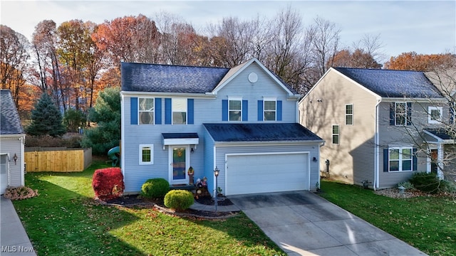 view of front property featuring a front lawn and a garage