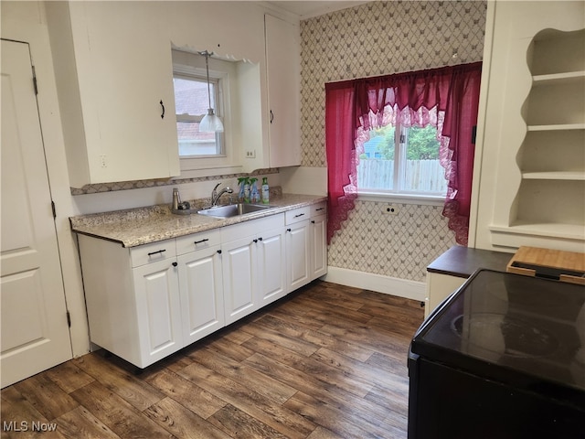 kitchen with black range with electric cooktop, white cabinetry, sink, and dark hardwood / wood-style flooring