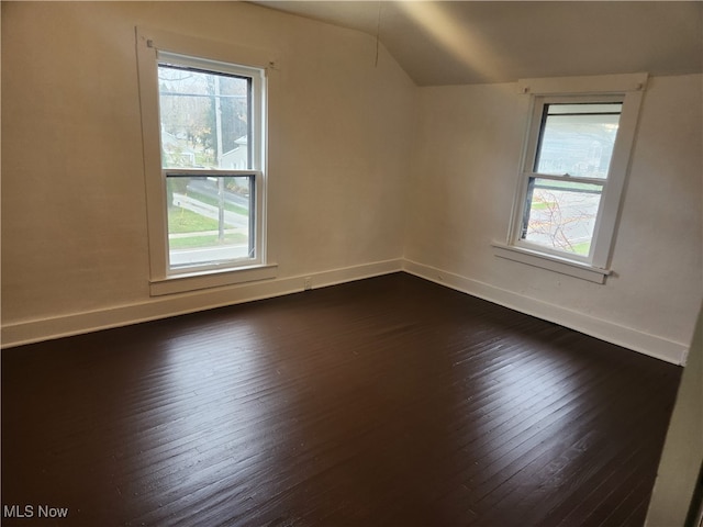 additional living space with dark hardwood / wood-style floors and vaulted ceiling