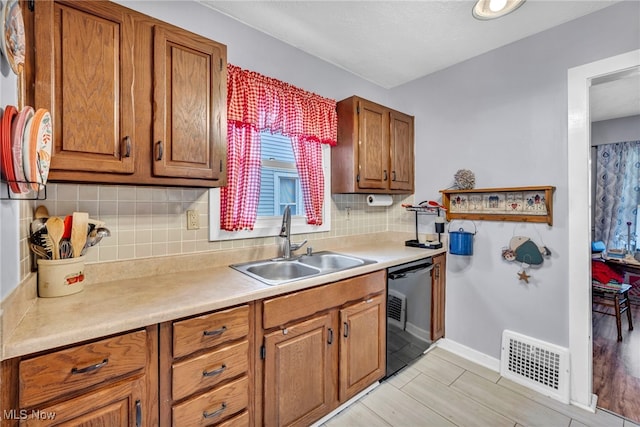 kitchen with dishwasher, backsplash, and sink