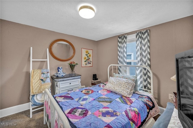 bedroom featuring dark carpet and a textured ceiling