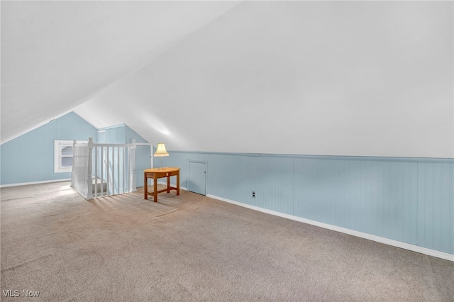 additional living space with carpet flooring and lofted ceiling