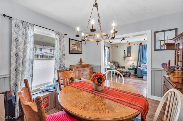 dining area featuring a chandelier, a textured ceiling, and light hardwood / wood-style flooring