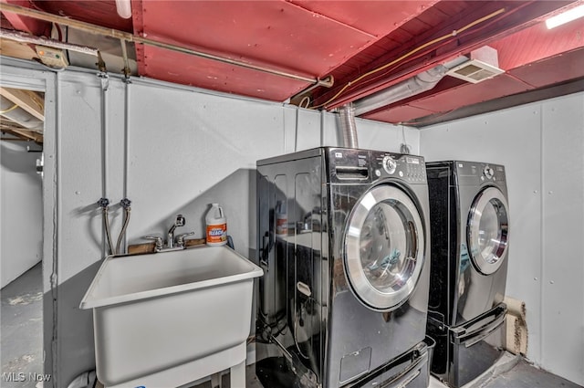 clothes washing area featuring sink and independent washer and dryer