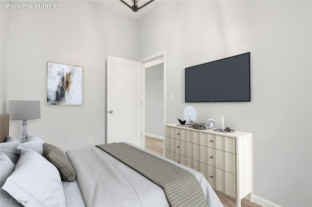 bedroom featuring hardwood / wood-style floors and a towering ceiling