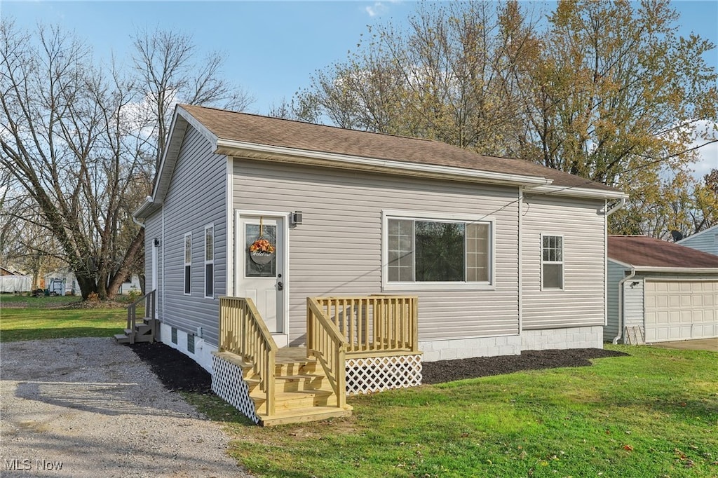 view of front of home featuring a garage, an outdoor structure, and a front lawn