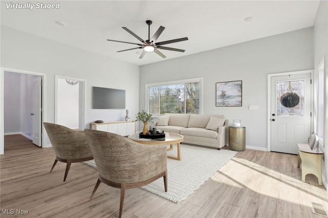 living room with light wood-type flooring and ceiling fan