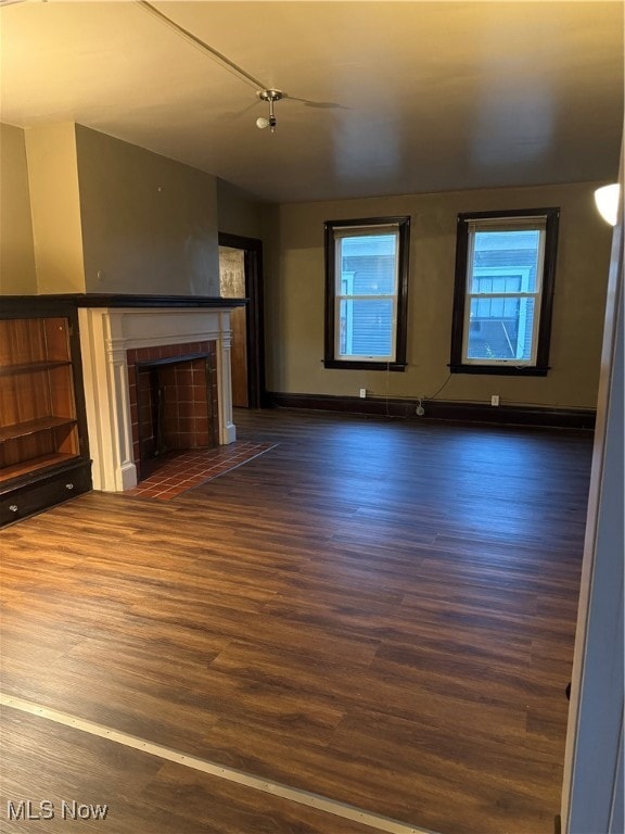 unfurnished living room with dark hardwood / wood-style flooring and a fireplace