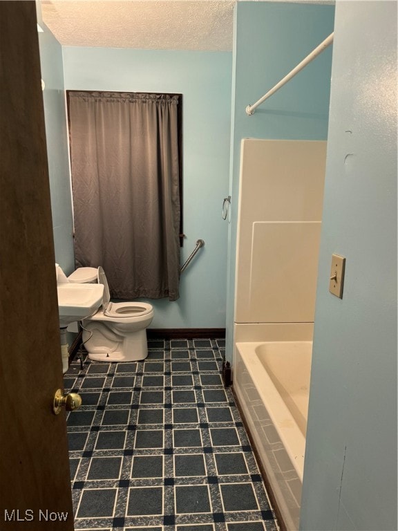 bathroom featuring a textured ceiling and toilet