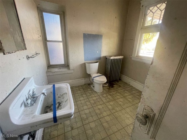 bathroom featuring radiator heating unit and toilet