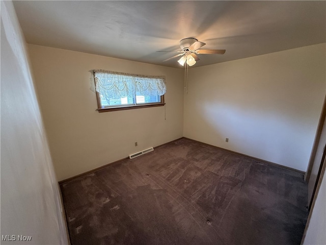 carpeted spare room featuring ceiling fan