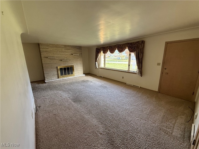 unfurnished living room featuring carpet floors and a fireplace