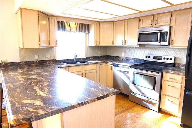 kitchen with stainless steel appliances, sink, and light brown cabinets