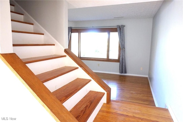 stairway featuring wood-type flooring