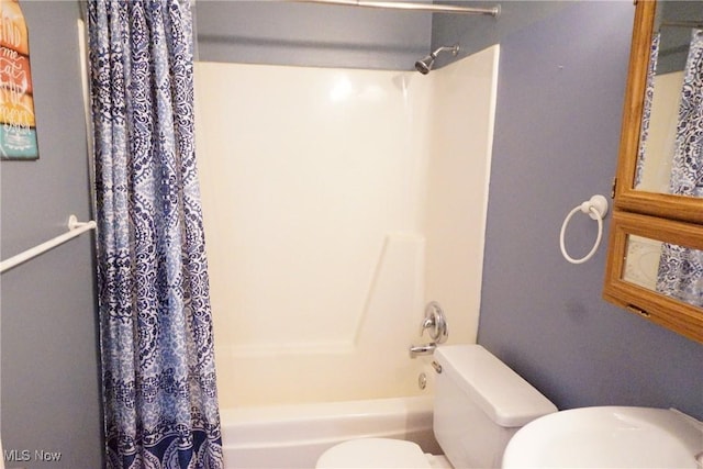 bathroom featuring shower / tub combo and toilet