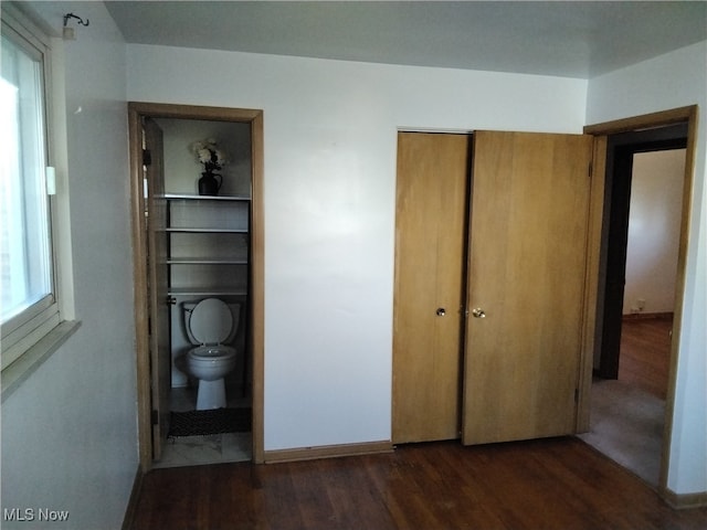 unfurnished bedroom featuring dark hardwood / wood-style flooring and a closet