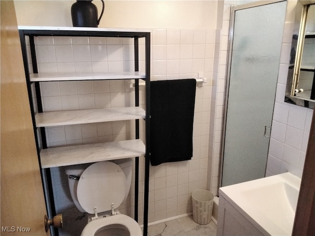 bathroom with tile walls, an enclosed shower, and toilet