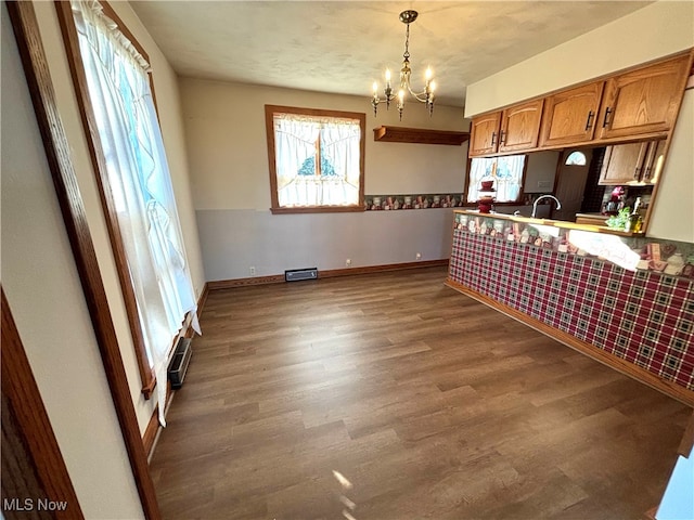 kitchen with sink, a textured ceiling, an inviting chandelier, hanging light fixtures, and dark wood-type flooring