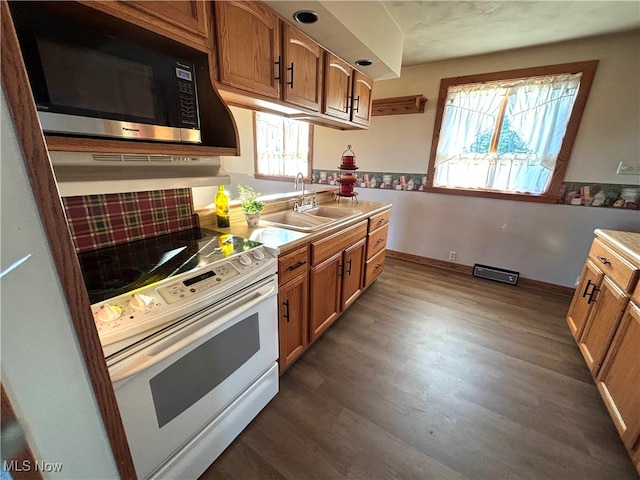 kitchen with dark wood-type flooring, electric stove, sink, and a healthy amount of sunlight