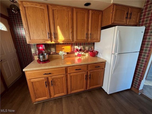 kitchen featuring dark wood-type flooring, tasteful backsplash, and white fridge