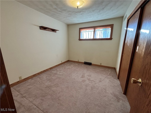 carpeted spare room with a textured ceiling