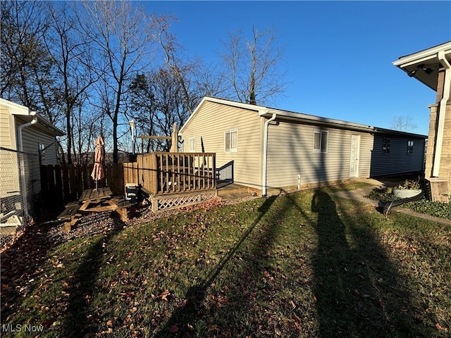 rear view of house with a yard and a deck