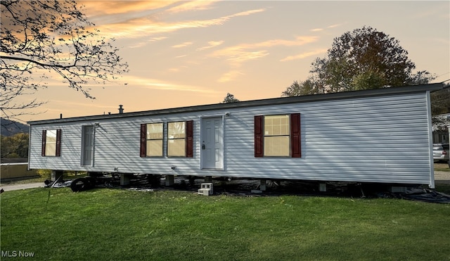 property exterior at dusk with a yard