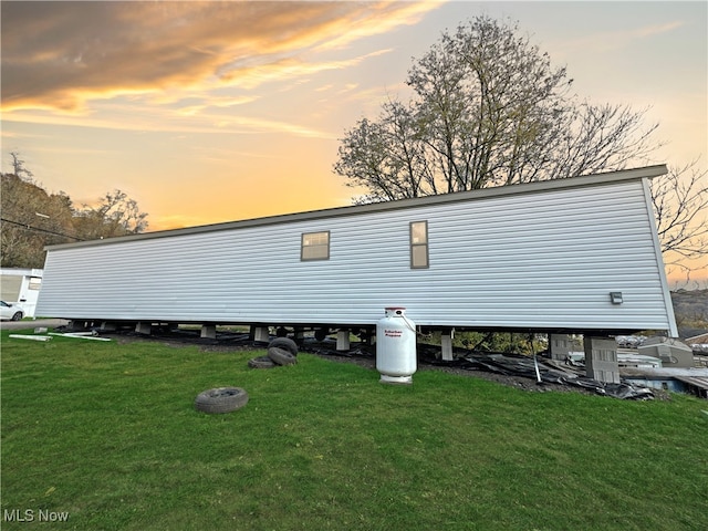 property exterior at dusk with a yard