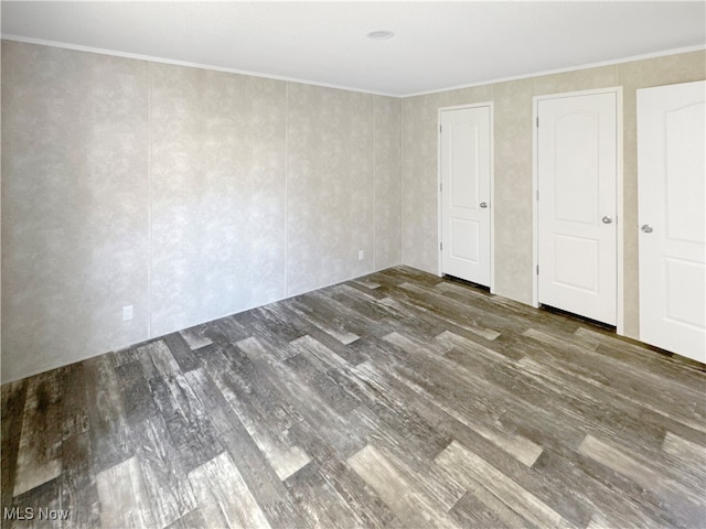 unfurnished bedroom featuring dark wood-type flooring and crown molding