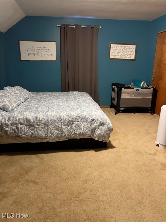 bedroom featuring lofted ceiling and light colored carpet