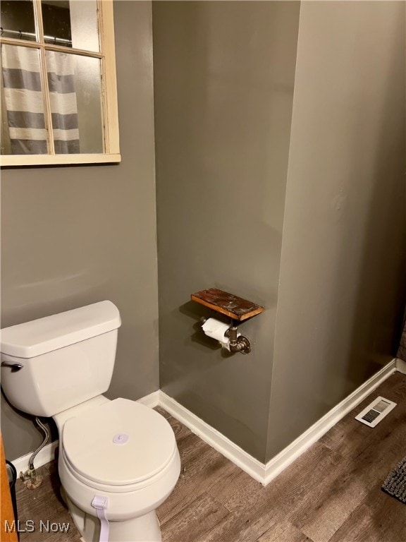 bathroom with hardwood / wood-style flooring and toilet