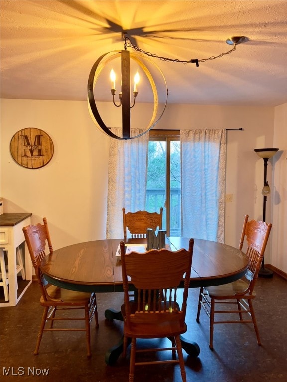 dining area with a textured ceiling and a notable chandelier