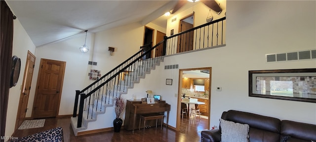 stairs with high vaulted ceiling and wood-type flooring