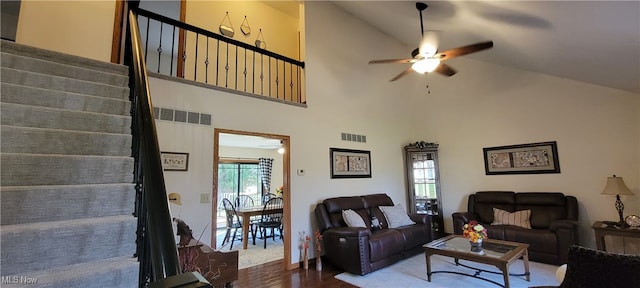 living room with hardwood / wood-style floors, high vaulted ceiling, and plenty of natural light