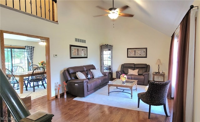 living room featuring wood-type flooring, high vaulted ceiling, a wealth of natural light, and ceiling fan