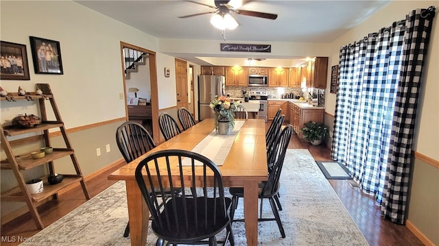 dining room with ceiling fan, sink, and wood-type flooring