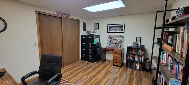 office area featuring hardwood / wood-style floors and a drop ceiling