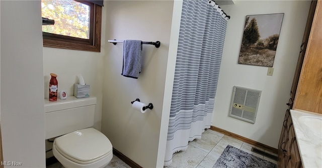 bathroom with heating unit, vanity, toilet, walk in shower, and tile patterned flooring