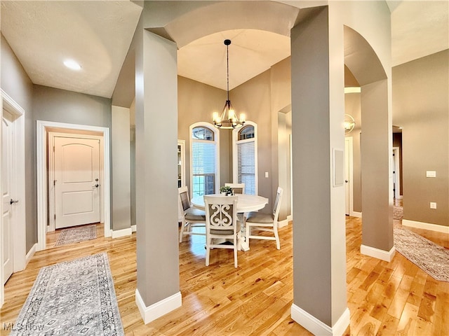 dining area with hardwood / wood-style floors and an inviting chandelier