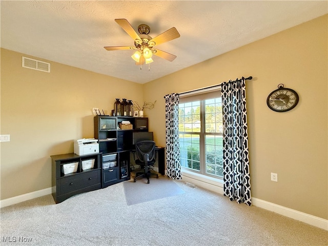 carpeted office featuring ceiling fan and a textured ceiling