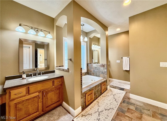 bathroom featuring vanity and a relaxing tiled tub