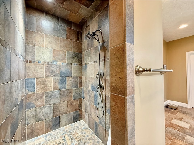 bathroom featuring tiled shower and a textured ceiling