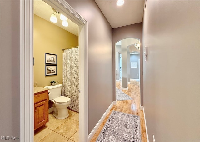 bathroom with hardwood / wood-style floors, vanity, and toilet