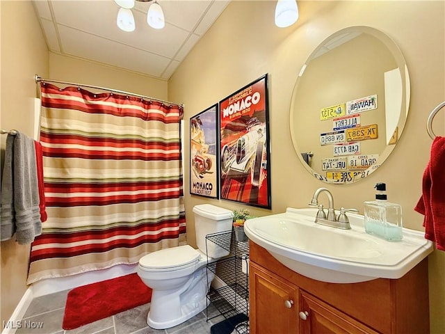 bathroom featuring a paneled ceiling, a shower with curtain, vanity, tile patterned flooring, and toilet